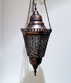 an ornate hanging light fixture on a white wall