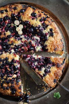 a cake with blueberries and other toppings is cut into slices on a plate