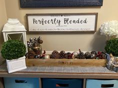 a wooden box filled with pine cones on top of a table next to blue bins