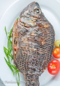 a white plate topped with fish and tomatoes