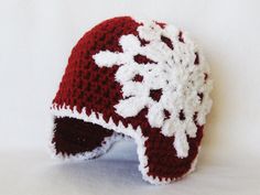 a crocheted red and white hat with snowflakes