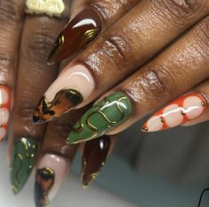 a woman's hands with different colored nail polishes on their nails and gold accents