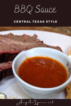 the bbq sauce is in a white bowl next to some meat on a plate