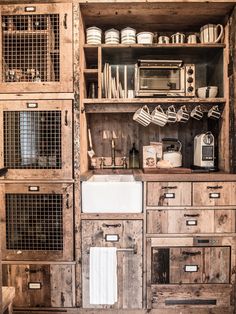 an old kitchen with wooden cabinets and white dishes on the counter top, including a sink