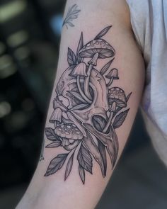 a black and white photo of a woman's arm with tattoos on it