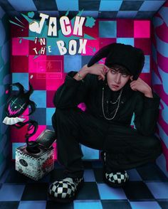 a young man sitting on top of a checkered floor in front of a box