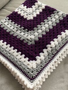 a crocheted blanket sitting on top of a couch