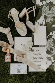 the wedding stationery was laid out on the grass and decorated with flowers, ribbons, and shoes