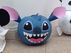 two pumpkins decorated to look like cartoon characters, one with ears and the other with eyes