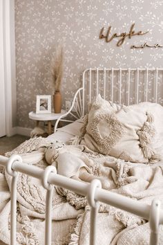 a white bed with pillows and blankets on it