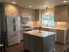 a kitchen with an island, stove and refrigerator