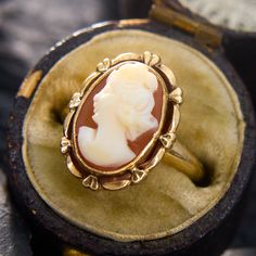 This sweet ring holds an oval shell cameo in a bezel setting, with a decorated goldwork frame. The ring is crafted in 10k yellow gold and currently fits a size 2.75. This ring will likely have limitations for how many sizes it can increase, so please feel free to call with sizing inquiries. Luxury Heirloom Jewelry With Fluted Bezel, Elegant Luxury Oval Cabochon Dome Ring, Luxury Vintage Oval Cabochon Dome Ring, Sweet Ring, Cameo Ring, Gold Work, Yellow Gold Rings, Bezel Setting, How Many