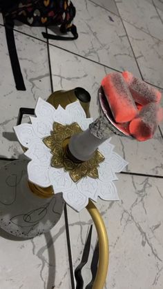 a white and gold flower on top of a metal stand with scissors next to it