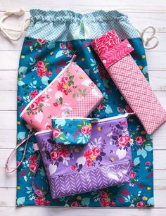 four colorful bags are sitting on a blue and pink floral print fabric with ties around them