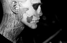 black and white photograph of a man with skull face paint on his head, looking off to the side