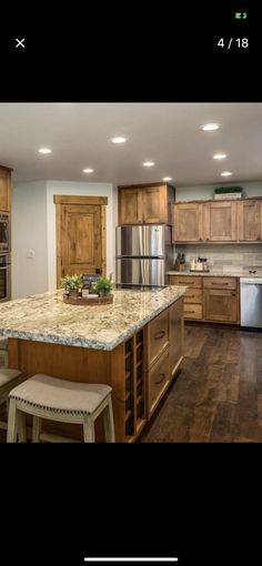 a large kitchen with wooden cabinets and granite counter tops, along with stainless steel appliances