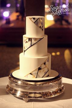 a white and gold wedding cake on top of a table