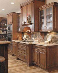 a kitchen filled with lots of wooden cabinets and counter top space next to an oven