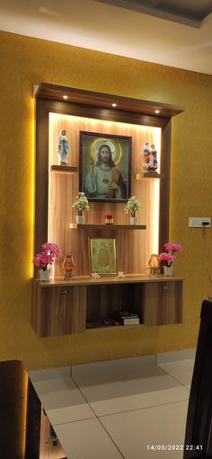 an image of the virgin mary on display in a wall mounted cabinet above a dining room table