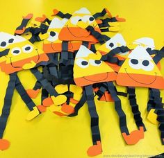 a group of cut out giraffes sitting on top of a yellow table