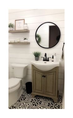 a white toilet sitting next to a bathroom sink under a round mirror on a wall