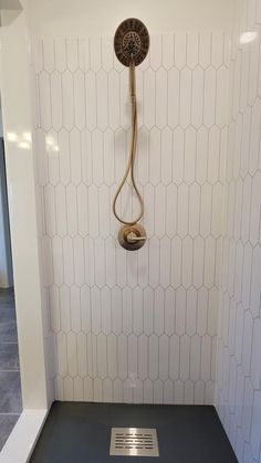 a shower head in the corner of a bathroom with hexagonal tiles on the walls