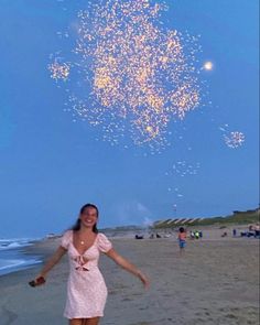 a woman standing on top of a sandy beach under a sky filled with stars and confetti