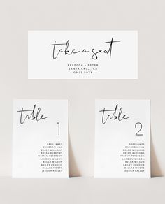 three place cards with black ink on white paper, one has the word take a seat