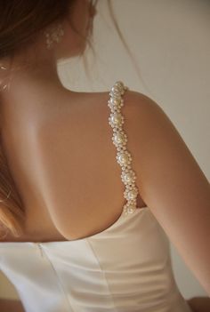 the back of a woman's dress with pearls on it