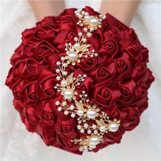 a bridal bouquet with red roses and pearls