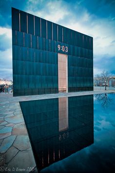 a building with a pool in front of it on a cloudy day at dusk or dawn