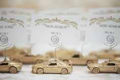 some gold cars are sitting next to each other on a table with place cards in front of them