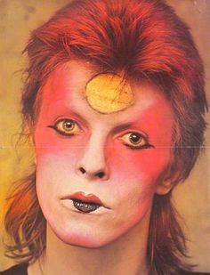 a man with red hair and yellow eyes has his face painted like a woman's head