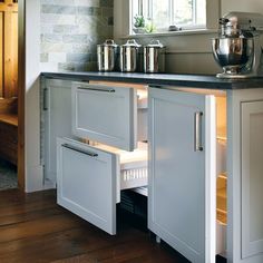 an open cabinet door in a kitchen with pots and pans