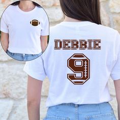 Score big with our Football Player T-shirt! Whether you're on the field or cheering from the sidelines, this Football Jersey T-shirt is perfect for showing off your team spirit. Personalize it with a Custom Name and Number Football Shirt for a truly unique look. It's the ideal Football Shirt Gift for players, fans, or anyone who loves the game! How to Order,  -All scroll pictures -Select the Size and Color of the Product from the drop-down menus - Select Quantity - Add your table and place your Sports Fan T-shirt For Baseball Season, Collegiate T-shirt With Name Print For Fans, School Spirit T-shirt With Sublimation Print For Sports Events, Game Day Sports Fan T-shirt With Crew Neck, Collegiate T-shirt For Football Season Fan Merchandise, Collegiate T-shirt With Sublimation Print For Game Day, Collegiate Crew Neck Sublimation Design For Football Season, Collegiate Style T-shirt For Football Season Fan Merchandise, Collegiate Style T-shirt For Football Season