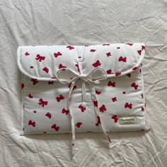 a white pillow with red bows on it