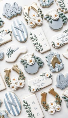 decorated cookies are arranged on a table with white and blue decorations in the shape of letters