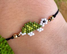 a green and white beaded bracelet on someone's arm