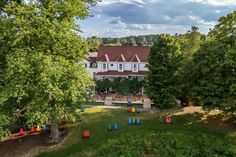 an aerial view of a large white house surrounded by trees