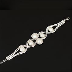 Bring sparkle and shine to your daily looks with this elegant bracelet that features pearls and glittering cubic zirconia accents. 1.26" H x 7.48" L with 1.38" extender Lobster claw clasp Silver-plated copper / cubic zirconia / pearl Pearl Embellished Party Bracelet, Silver Pearl Bracelet For Party, Elegant Alloy Bracelets With Rhinestones, Elegant Metal Bracelets With Rhinestones, Elegant Beaded Bracelets With Sparkling Stones For Party, Silver Pearl Chain Bracelet For Parties, Adjustable Crystal Pearl Bracelet For Party, White Alloy Bracelets For Party, Party Jewelry With Pearl Chain And Cubic Zirconia