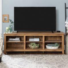 a flat screen tv sitting on top of a wooden entertainment center in a living room