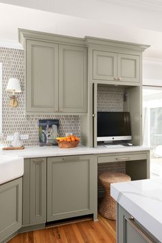 a kitchen with gray cabinets and white counter tops