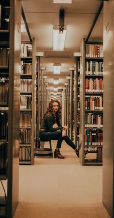 a woman sitting on a chair in the middle of a library