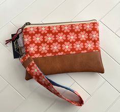 an orange and brown flowered purse on a white tile floor