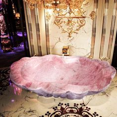 a fancy bathtub in the middle of a room with chandelier above it