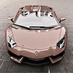 a shiny brown sports car is parked on the street