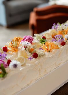 a close up of a cake with white frosting and colorful flowers on the top