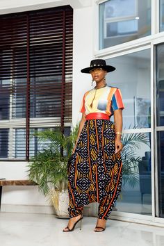 A woman posing in multicolored African Print parachute pants. Pantalon Orange, African Pants, Parachute Pant, Afrocentric Fashion, Clothes Fabric, African Fashion Modern, African Inspired Fashion, African Clothing Styles, Dope Fashion