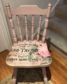 a wooden chair with a pink flower on the seat and words painted on the back