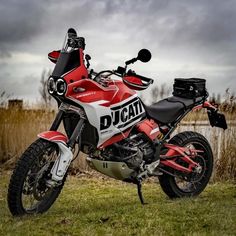 a red and white motorcycle parked in the grass